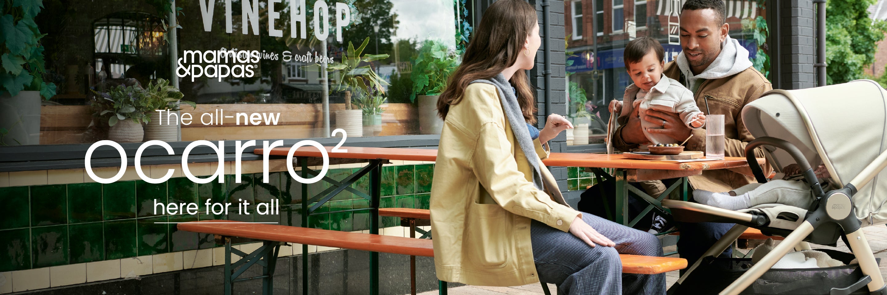 Family sitting at an outdoor cafe with a the Mamas & Papas Ocarro 2 Pram